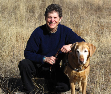 Photo of author kneeling with her Golden Retriever-Yellow Labrador guide dog Teela